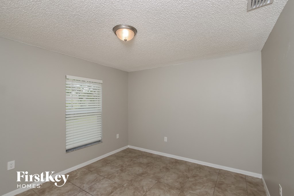 the living room of a home with a tile floor and a window