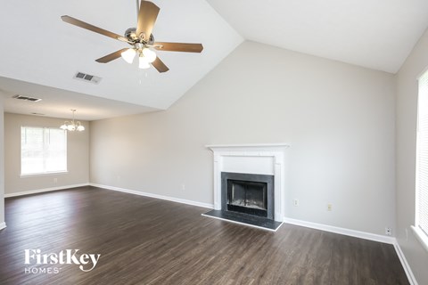 the living room with fireplace and ceiling fan