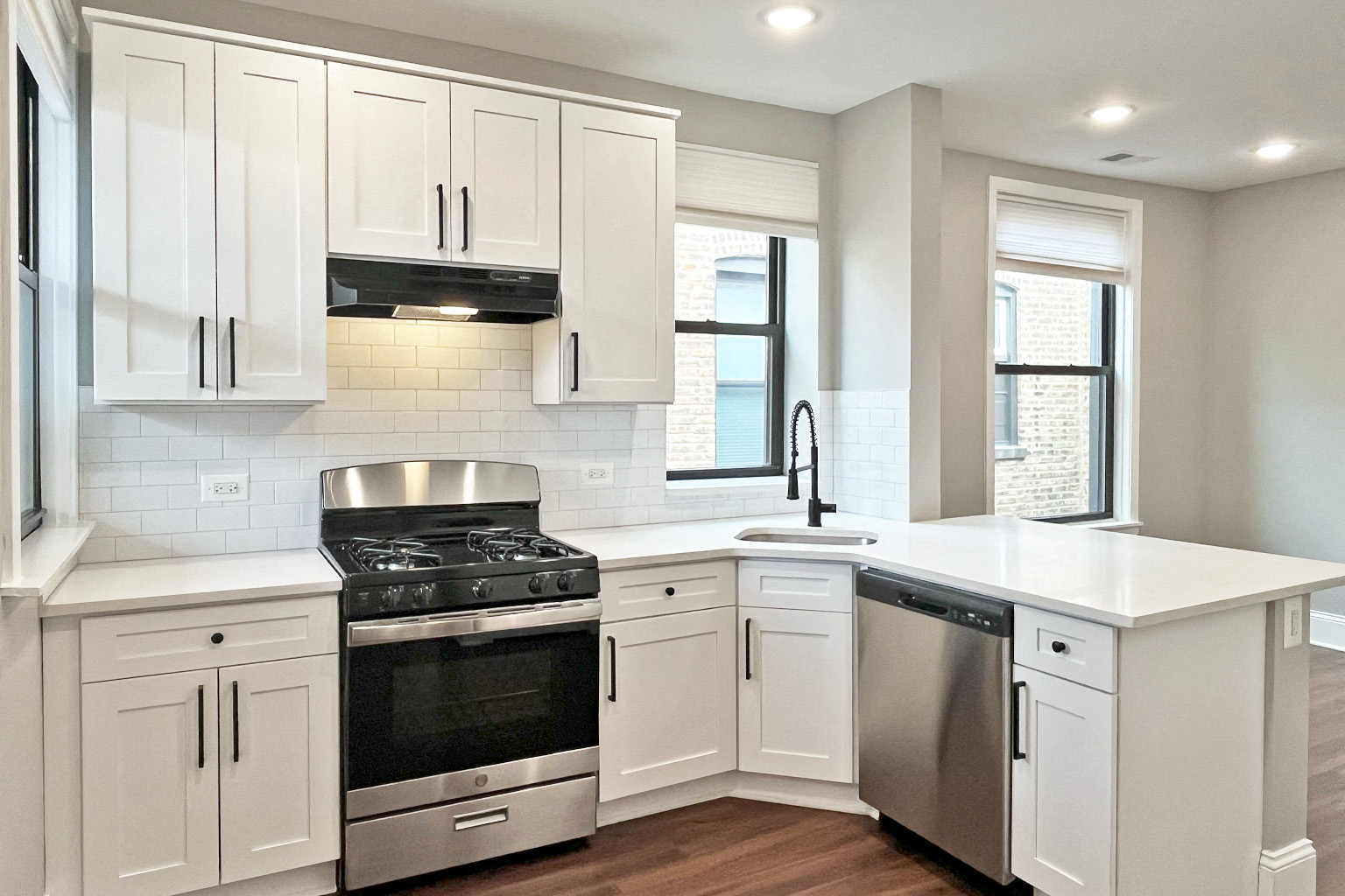 A kitchen with white cabinets and stainless steel appliances.