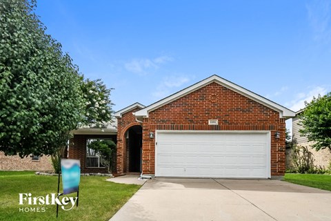 the front of a brick house with a white garage door