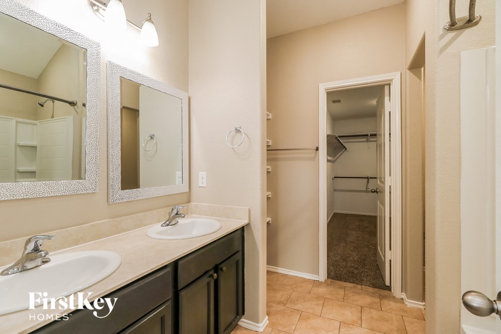 a bathroom with two sinks and a mirror and a closet