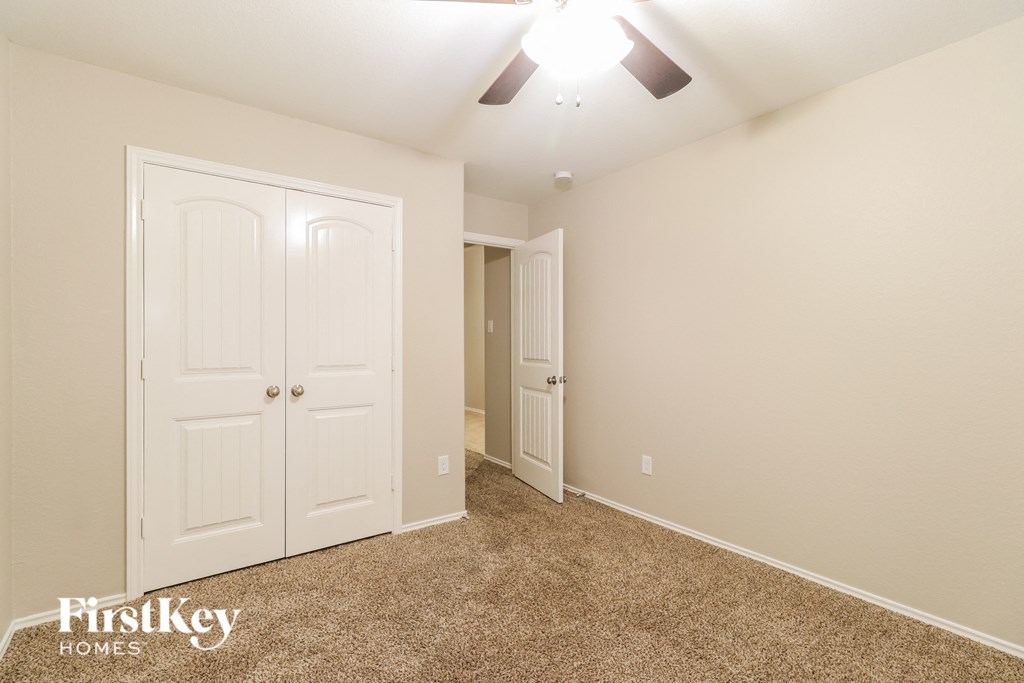 a bedroom with two closets and a ceiling fan