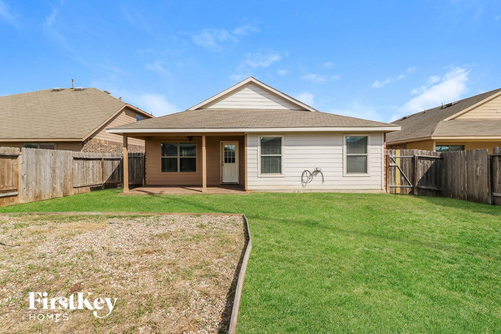 a small white house with a yard and a fence