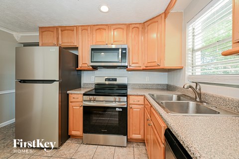 A kitchen with wooden cabinets and a stainless steel refrigerator.