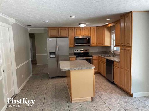 A kitchen with wooden cabinets and a refrigerator.