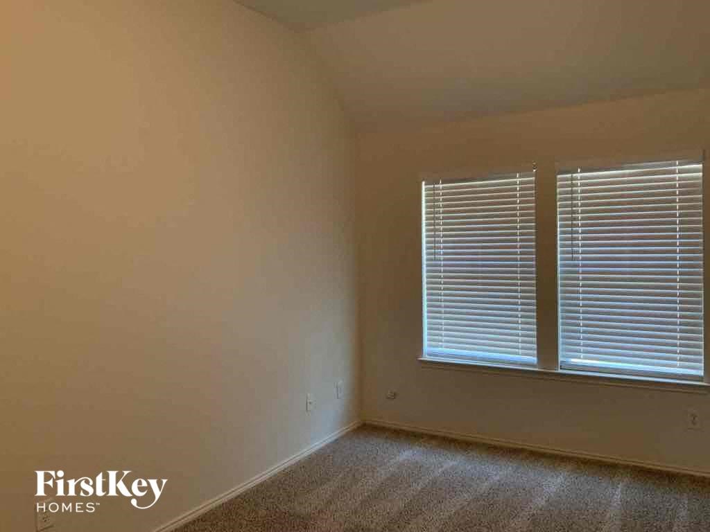 the bedroom of the house with a window and blinds
