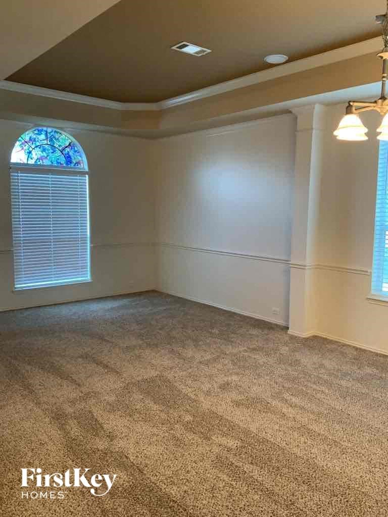 an empty living room with carpet and a window