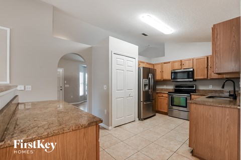 A kitchen with a granite countertop and wooden cabinets.