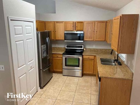 A kitchen with wooden cabinets and a granite countertop.
