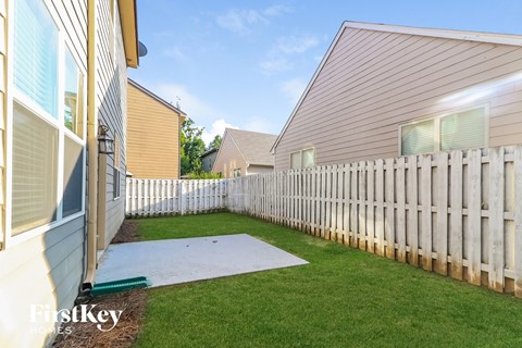 the backyard of a house with a white fence
