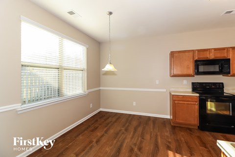 an empty kitchen with wood flooring and a large window