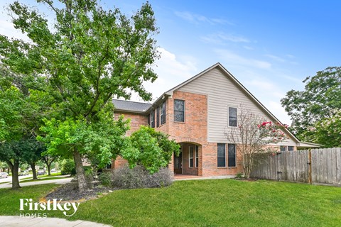 exterior view of a brick and with a yard and trees