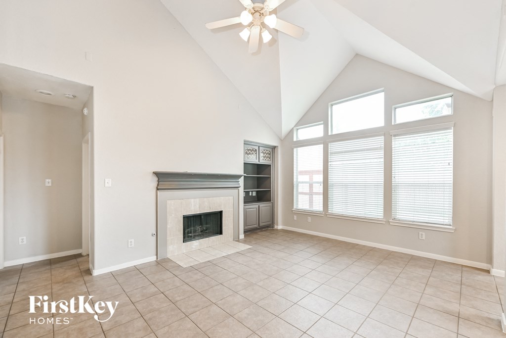 a living room with a fireplace and a ceiling fan