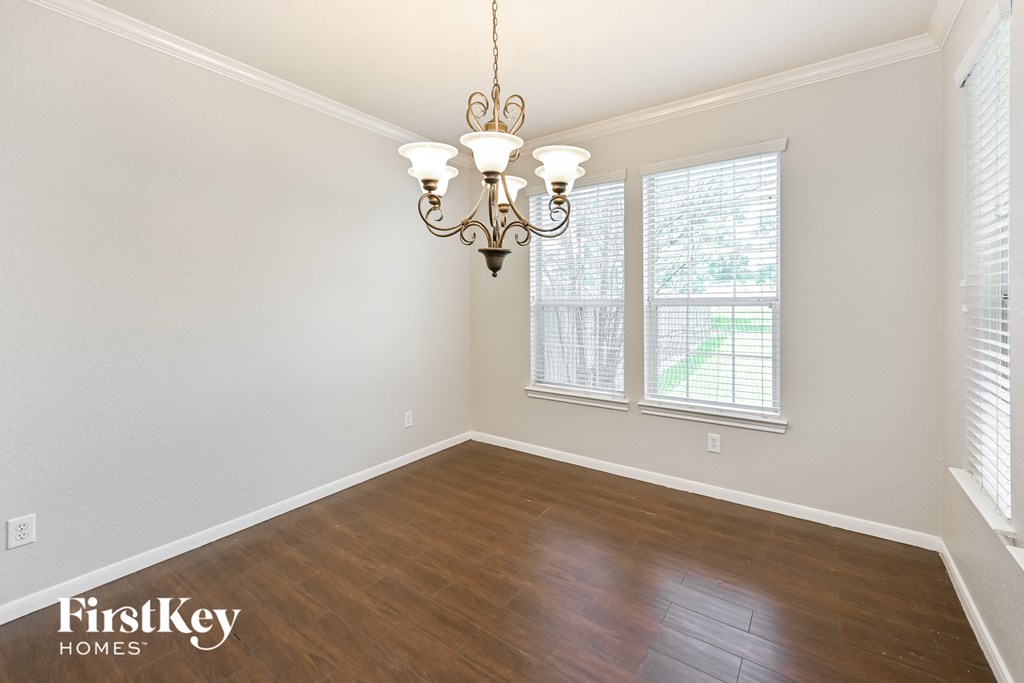 a dining room with wood flooring and a chandelier
