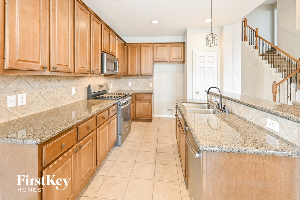a large kitchen with granite counter tops and wooden cabinets