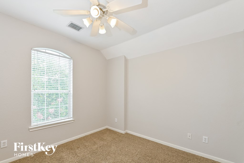 a bedroom with a ceiling fan and a window