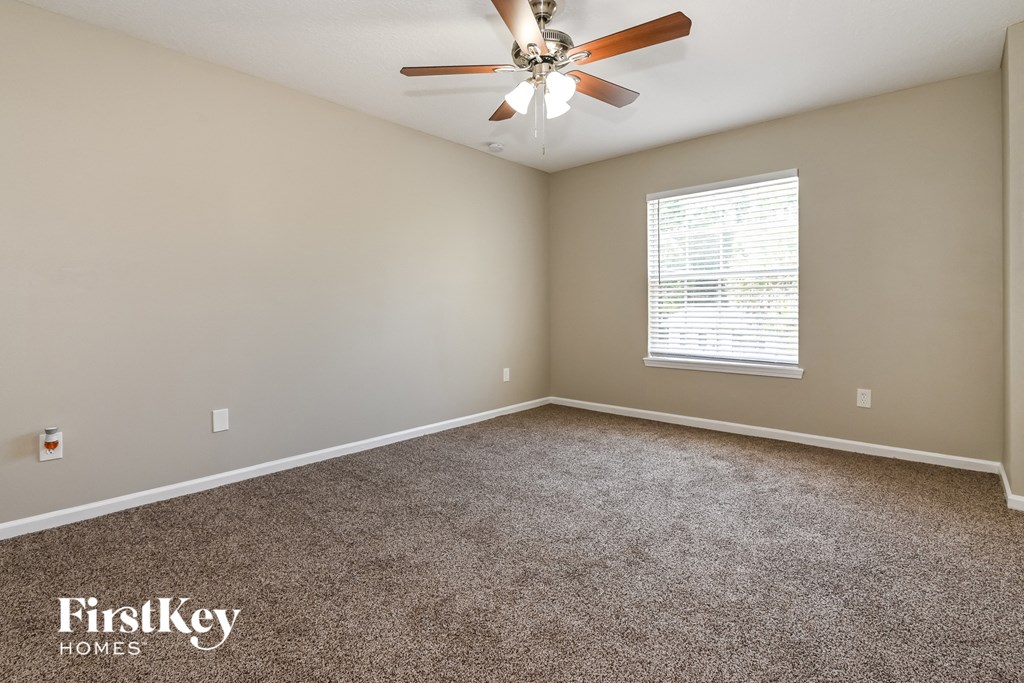a bedroom with carpet and a ceiling fan