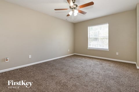 a bedroom with carpet and a ceiling fan