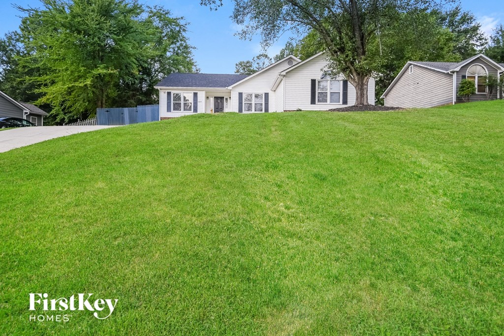 a white house on top of a grass covered hill