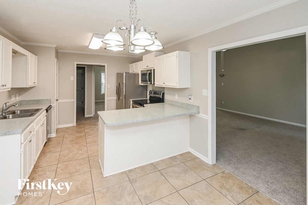 a kitchen with white cabinets and a counter top and a sink