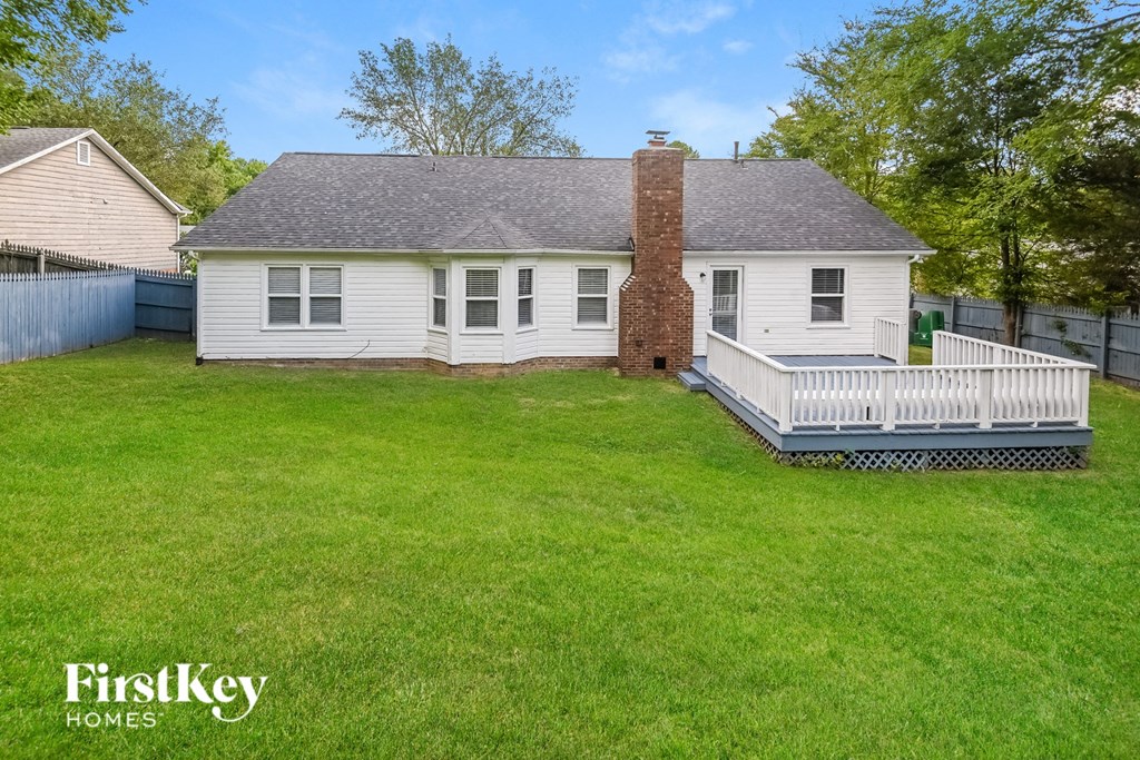 a white house with a white deck and a white fence