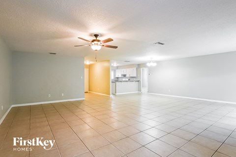 A spacious room with a ceiling fan and tiled flooring.