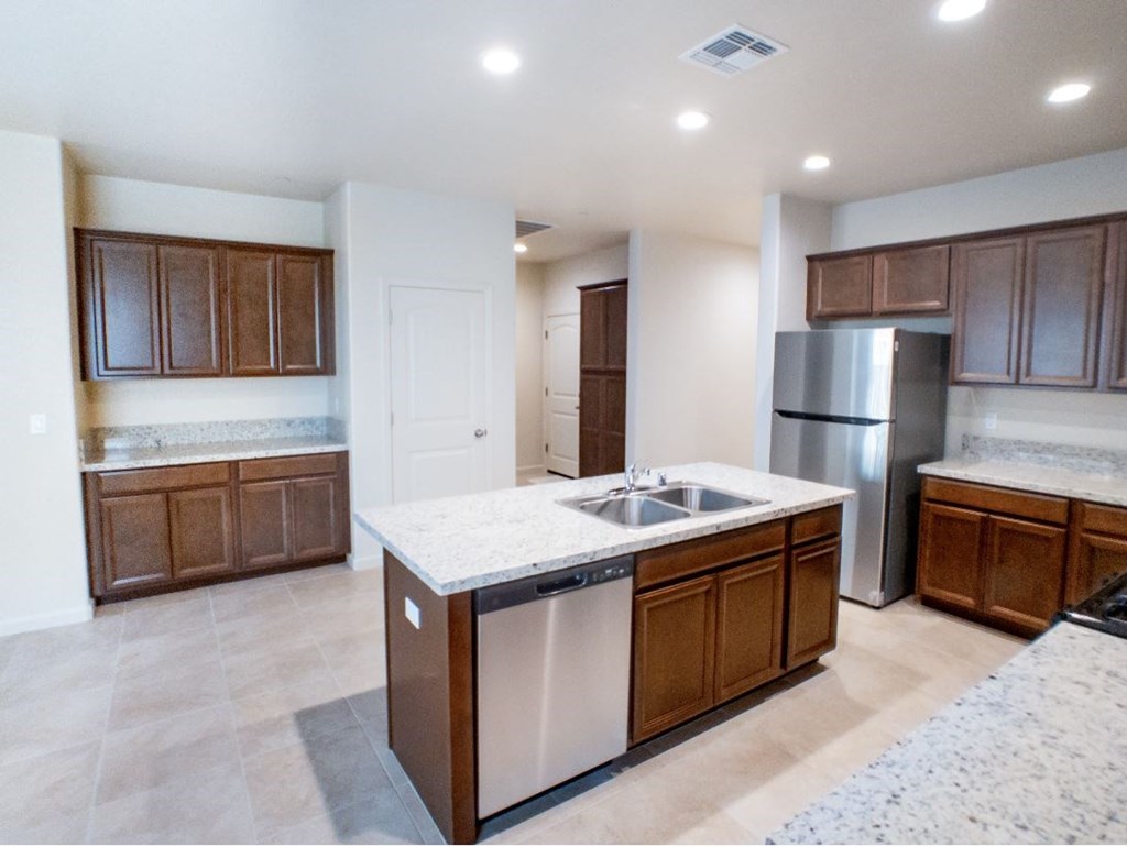 a kitchen with wooden cabinets and a stainless steel refrigerator