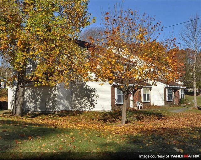 a white house with a tree in front of it