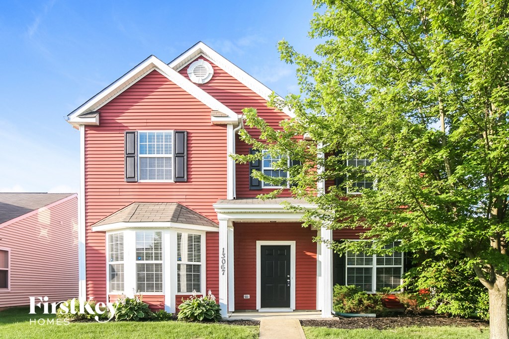 a red house with a tree in front of it