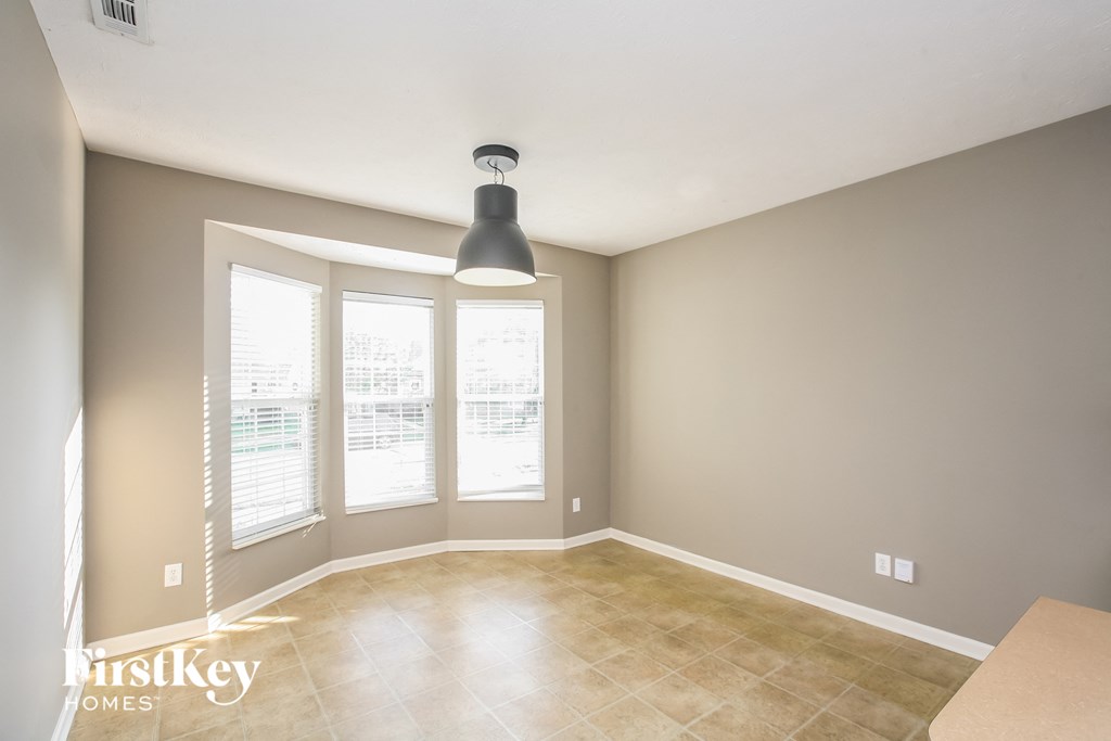 a dining room with a large window and a tile floor