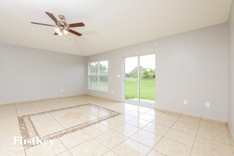 a living room with a ceiling fan and a tiled floor