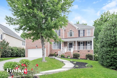 a large brick house with a tree in front of it