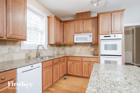 a kitchen with wooden cabinets and granite counter tops and white appliances