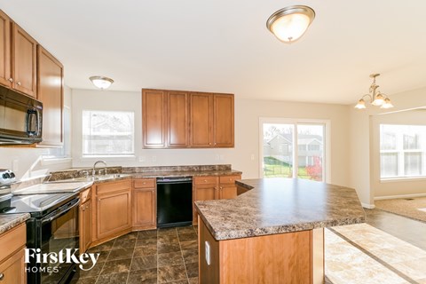 a kitchen with wooden cabinets and granite counter tops and a black stove top oven