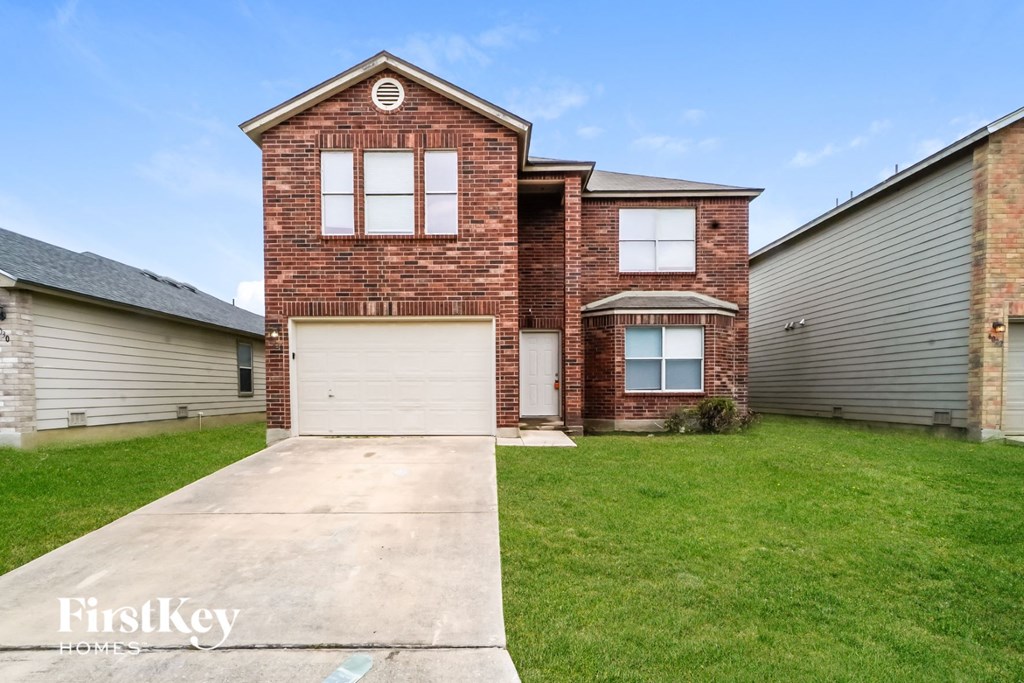 A brick house with a garage is for sale.