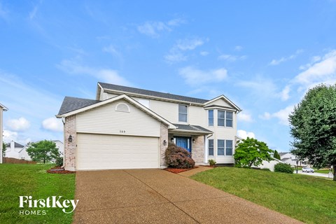 a white house with a driveway and a lawn