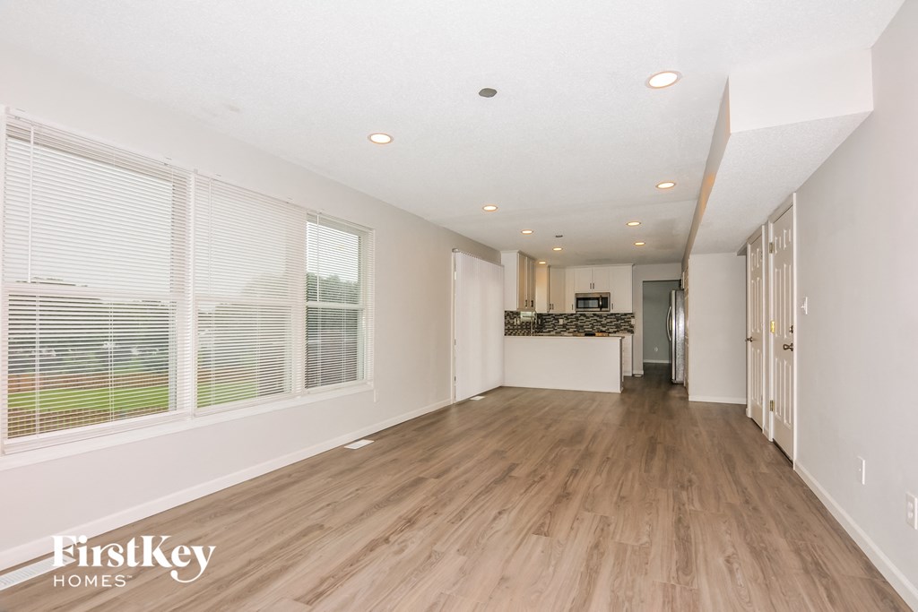 a spacious living room with wood floors and large windows