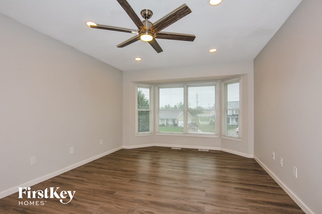 a living room with a large window and a ceiling fan