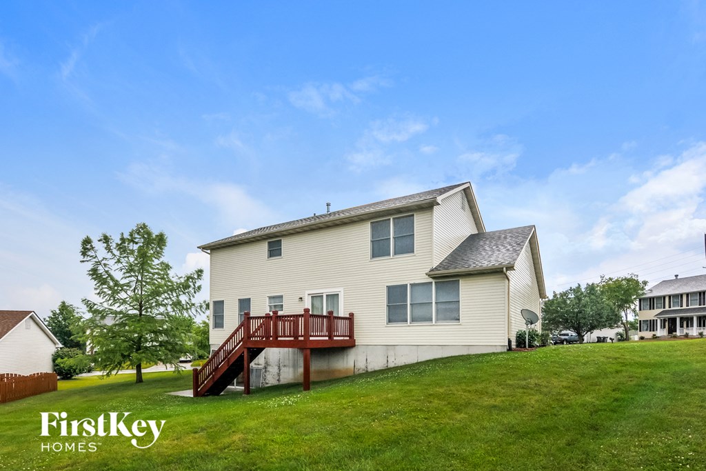 a white house with a red deck on a hill