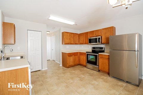 A kitchen with wooden cabinets and a stainless steel refrigerator.