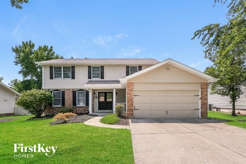 a white and brick house with a driveway and lawn