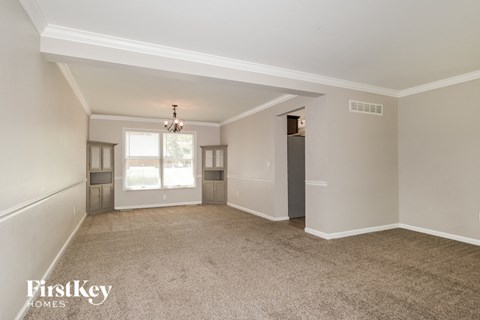 an empty living room with white walls and carpet