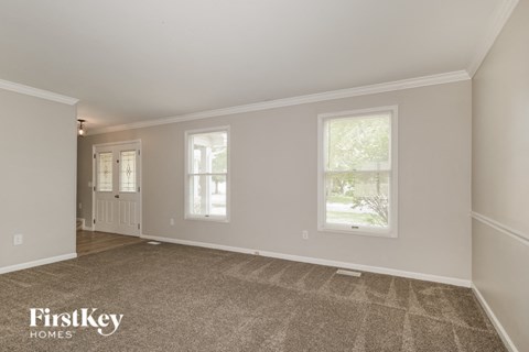 the living room and dining room of an empty house