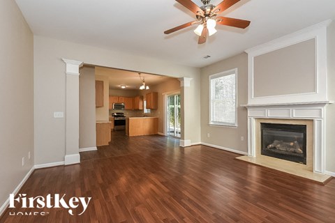 A spacious living room with wood flooring and a fireplace.