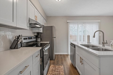 an open kitchen with white cabinets and stainless steel appliances