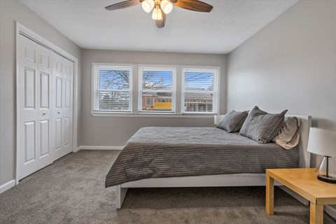 a bedroom with a bed and a ceiling fan