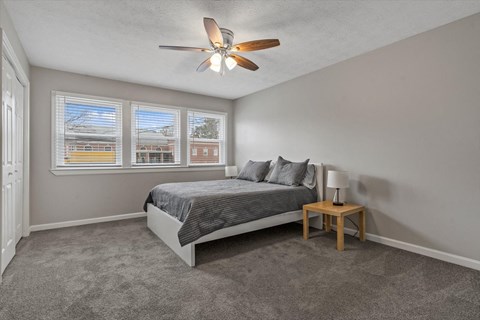 a bedroom with a bed and a ceiling fan