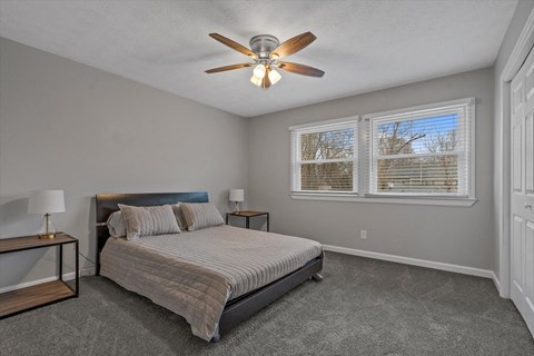 a bedroom with a bed and a ceiling fan