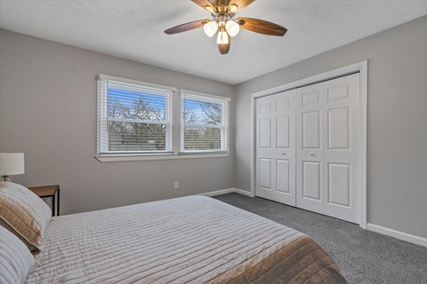 a bedroom with a bed and a ceiling fan