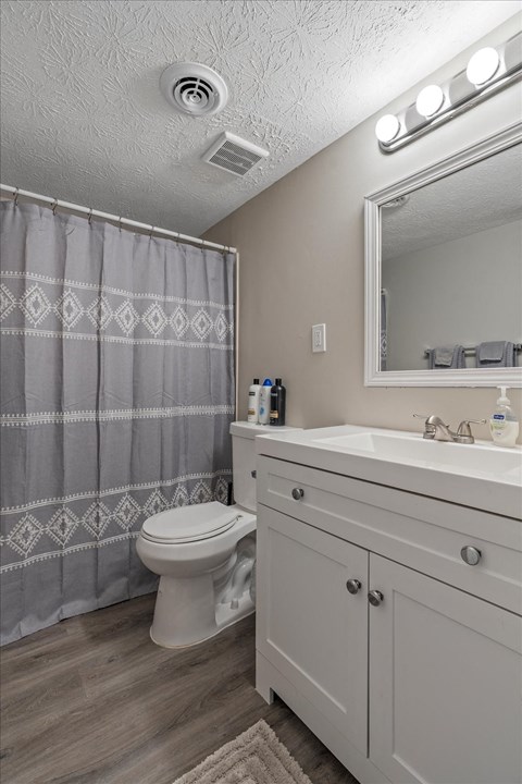 a bathroom with a shower and a toilet and a sink